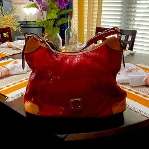 Dooney & Bourke red leather snake skin cut purse. Classic design with tan leathe